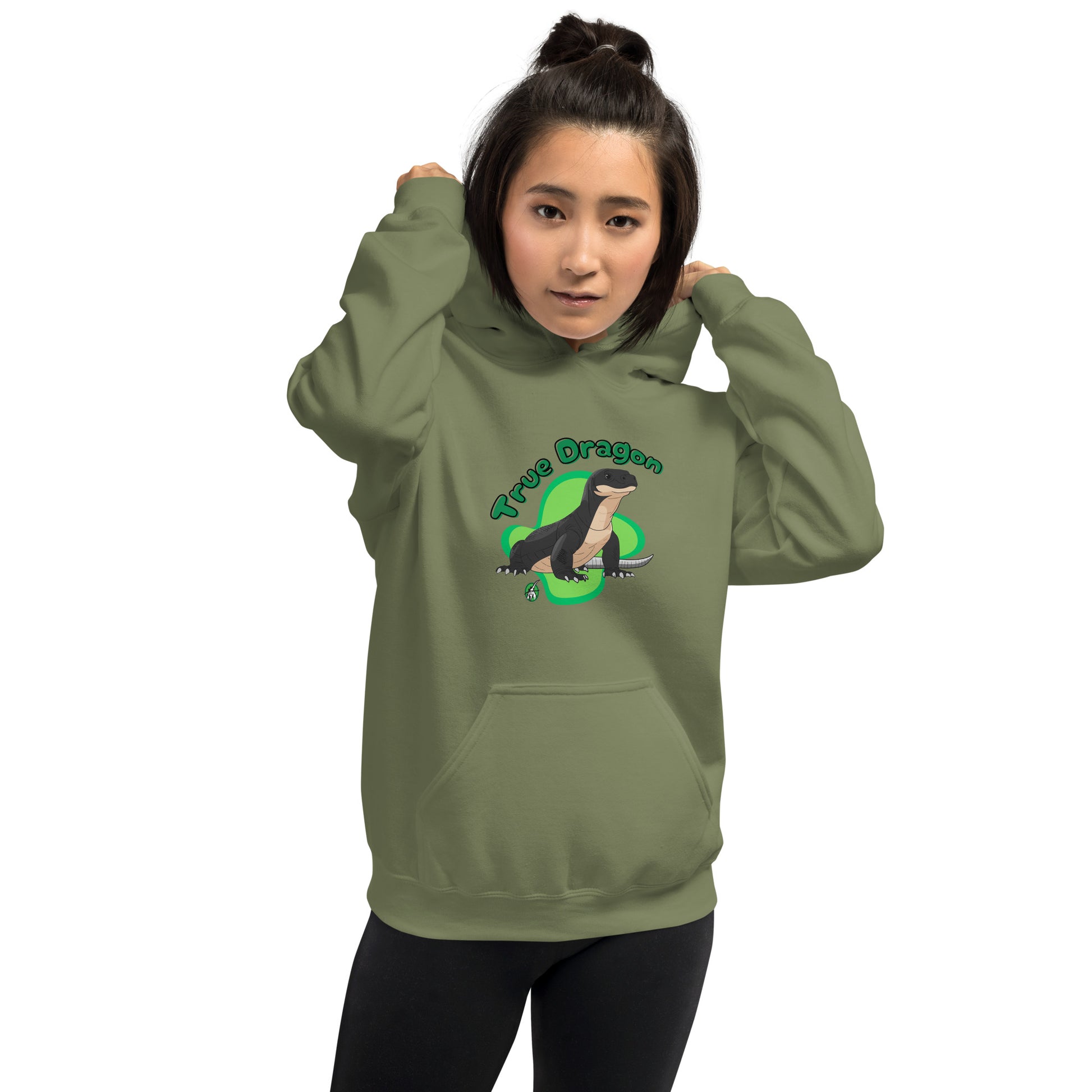 A woman standing wearing a military green hoodie with a printed graphic of a komodo dragon and the words, True Dragon. Designed by Wizard Prints.