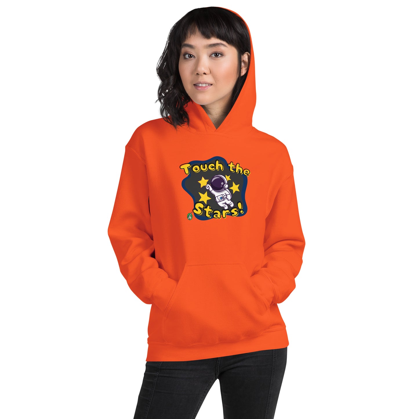 A woman standing wearing an orange hoodie with a printed graphic of a cartoon astronaut and the words, Touch the Stars. Designed by Wizard Prints.