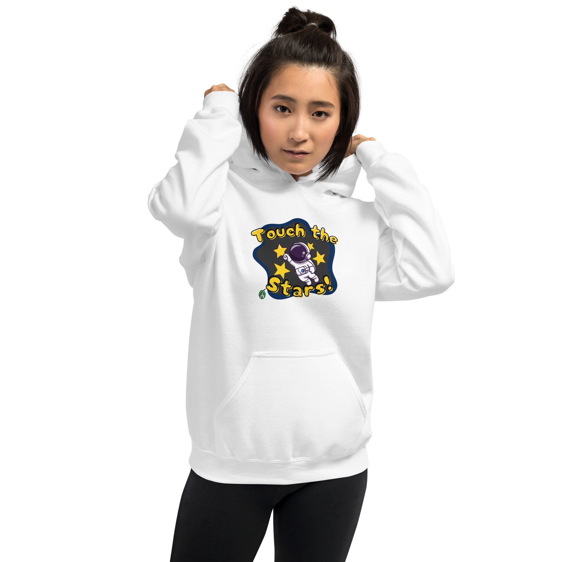 A woman standing wearing a white hoodie with a printed graphic of a cartoon astronaut and the words, Touch the Stars. Designed by Wizard Prints.