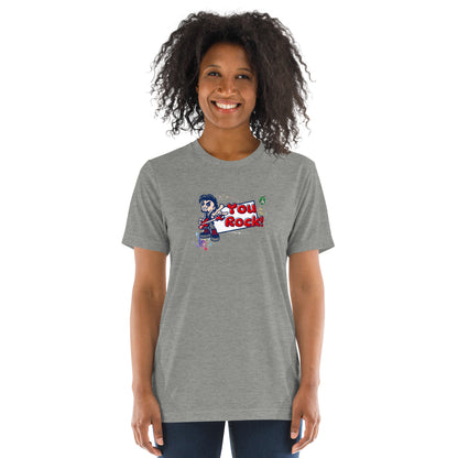 A woman standing wearing a grey t-shirt by Wizard Prints featuring a printed graphic of a rock singer holding an electric guitar and the words, You Rock!