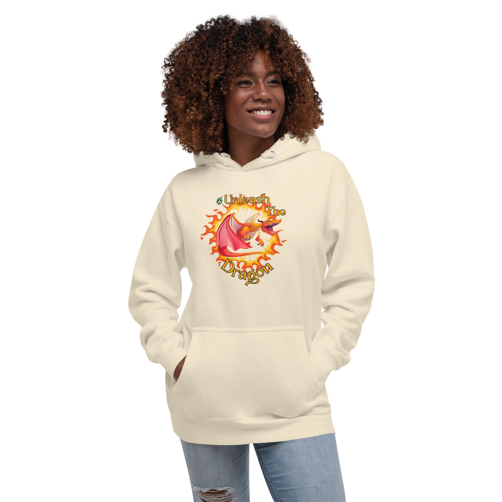 A woman standing wearing a beige hoodie with a printed graphic of a fire-breathing dragon with the words, 'Unleash the Dragon'. Designed by Wizard Prints.