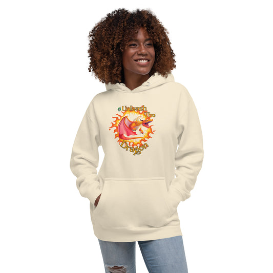 A woman standing wearing a beige hoodie with a printed graphic of a fire-breathing dragon with the words, 'Unleash the Dragon'. Designed by Wizard Prints.