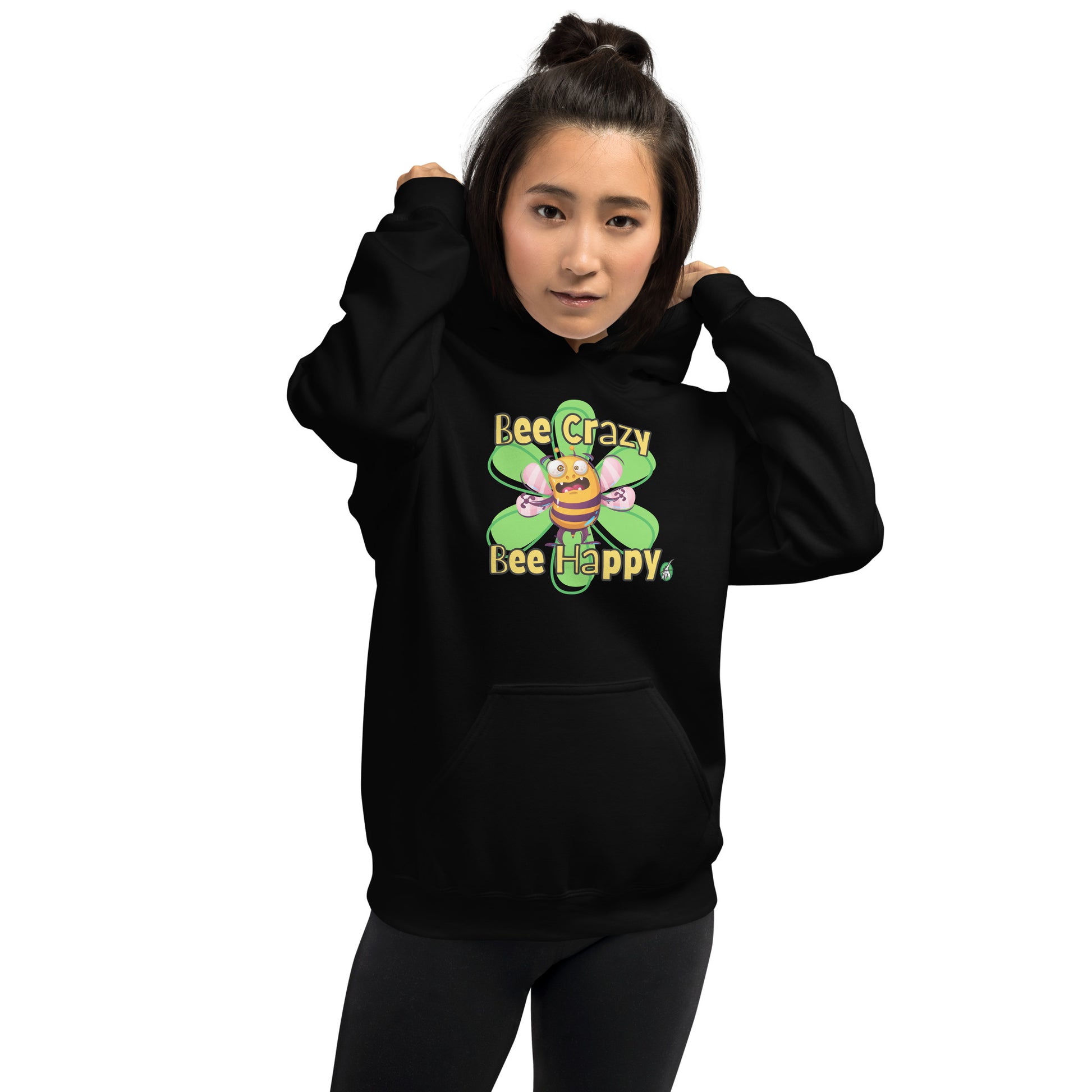 A woman standing wearing a black hoodie with a printed graphic of a bee with the words, 'Bee Crazy Bee Happy'. Designed by Wizard Prints.
