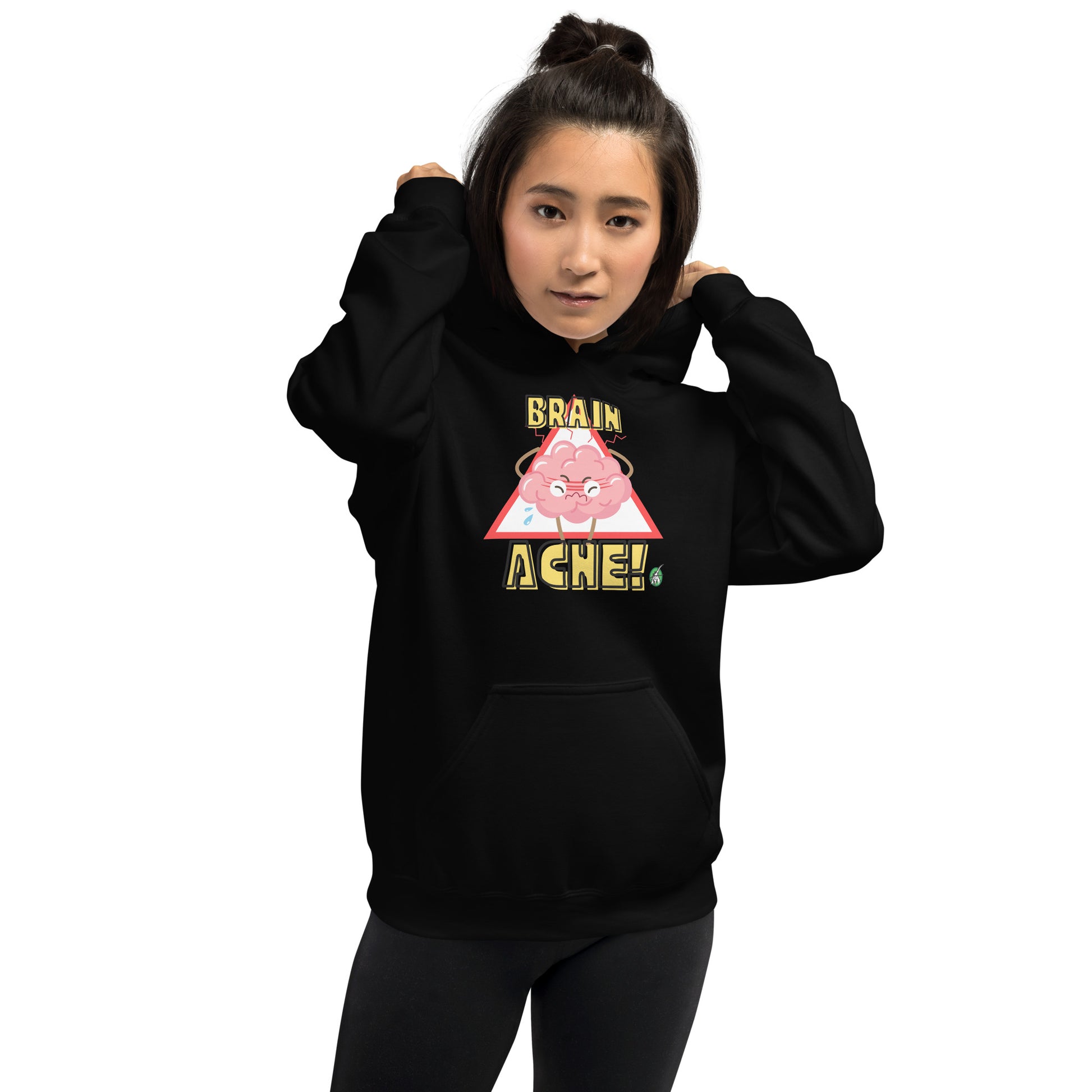 A woman standing wearing a black hoodie with a printed graphic of a brain with the words, Brain Ache. Designed by Wizard Prints.