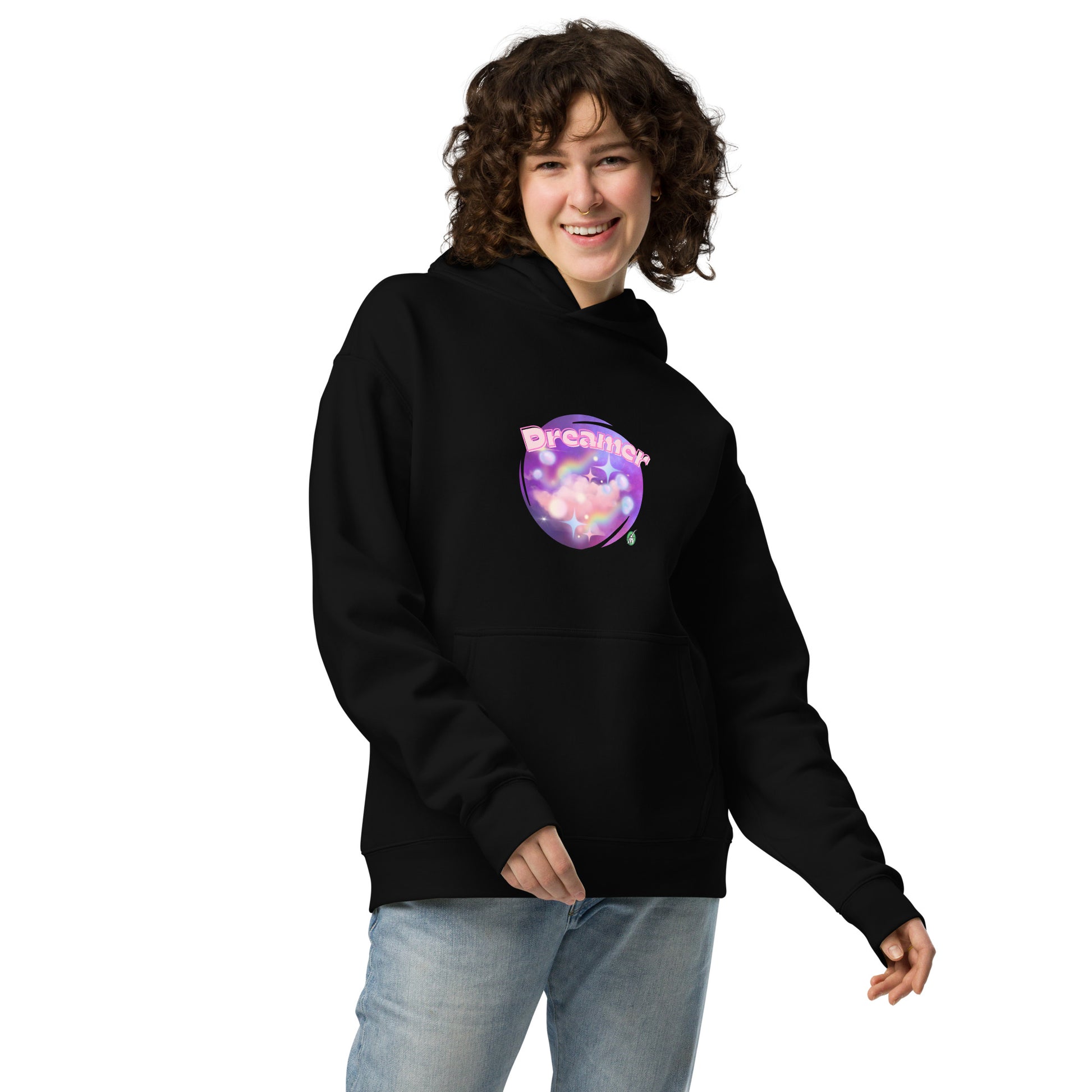 A woman standing wearing a black hoodie by Wizard Prints featuring a printed graphic of a galaxy background and the word Dreamer on top.