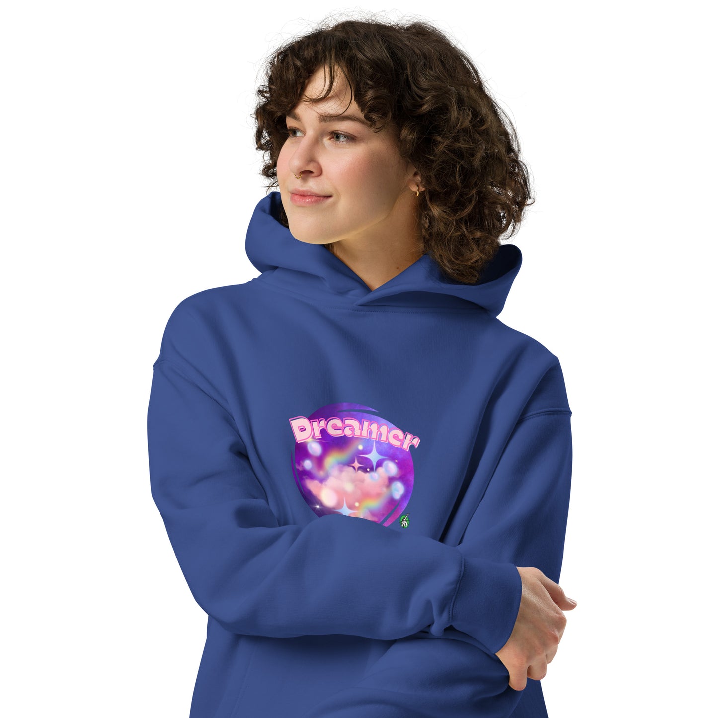 A woman standing wearing a blue hoodie by Wizard Prints featuring a printed graphic of a galaxy background and the word Dreamer on top.