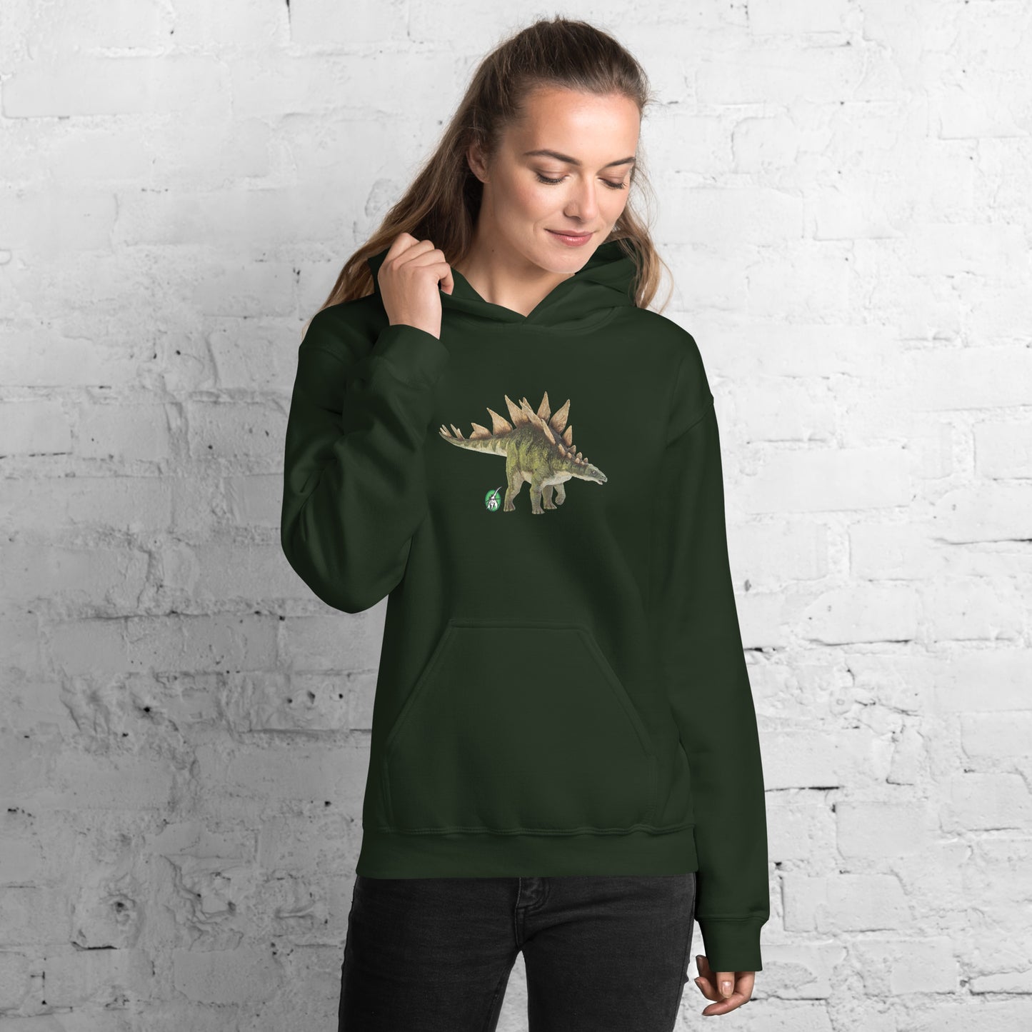 A woman standing wearing a forest green hoodie with a printed graphic of a life like dinosaur, designed by Wizard Prints