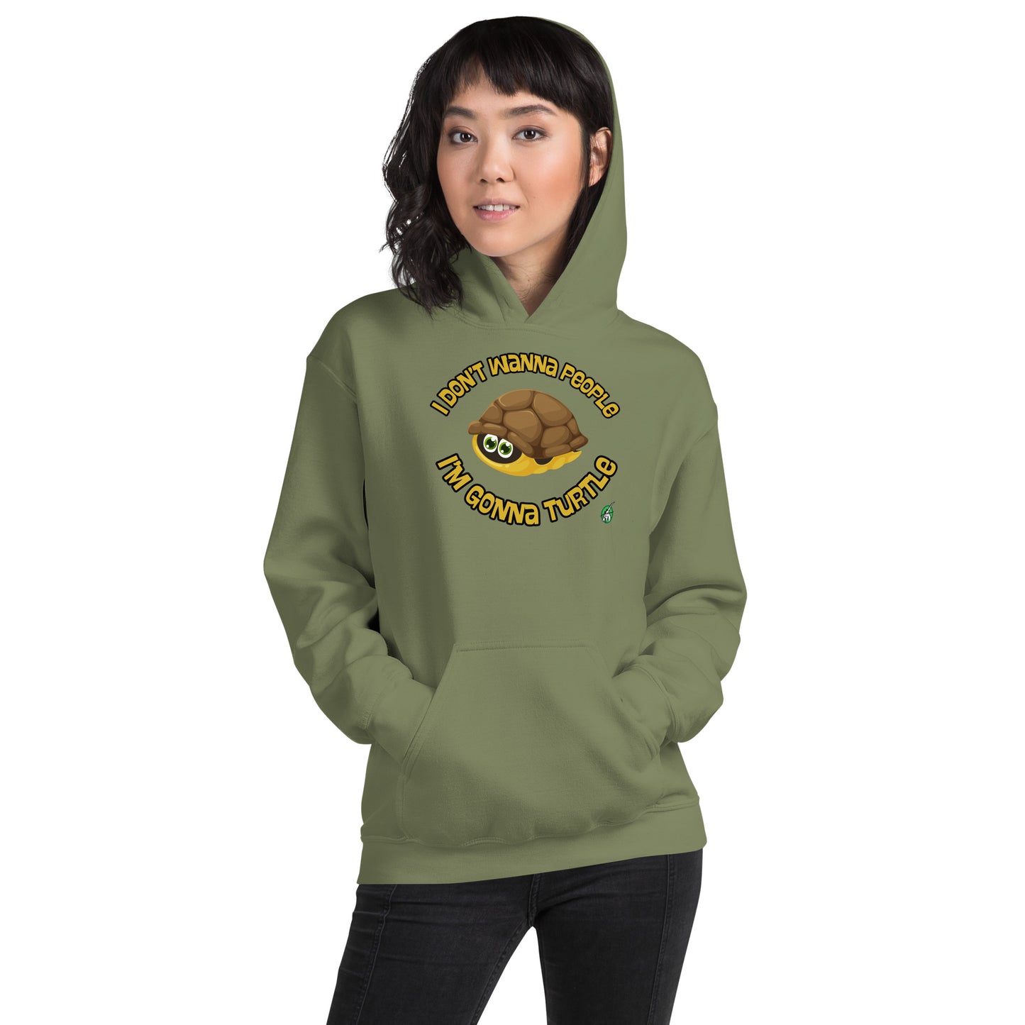 A woman standing wearing a military green hoodie with a printed graphic of a turtle with the words, 'I Don't Wanna People, I'm Gonna Turtle'. Designed by Wizard Prints.
