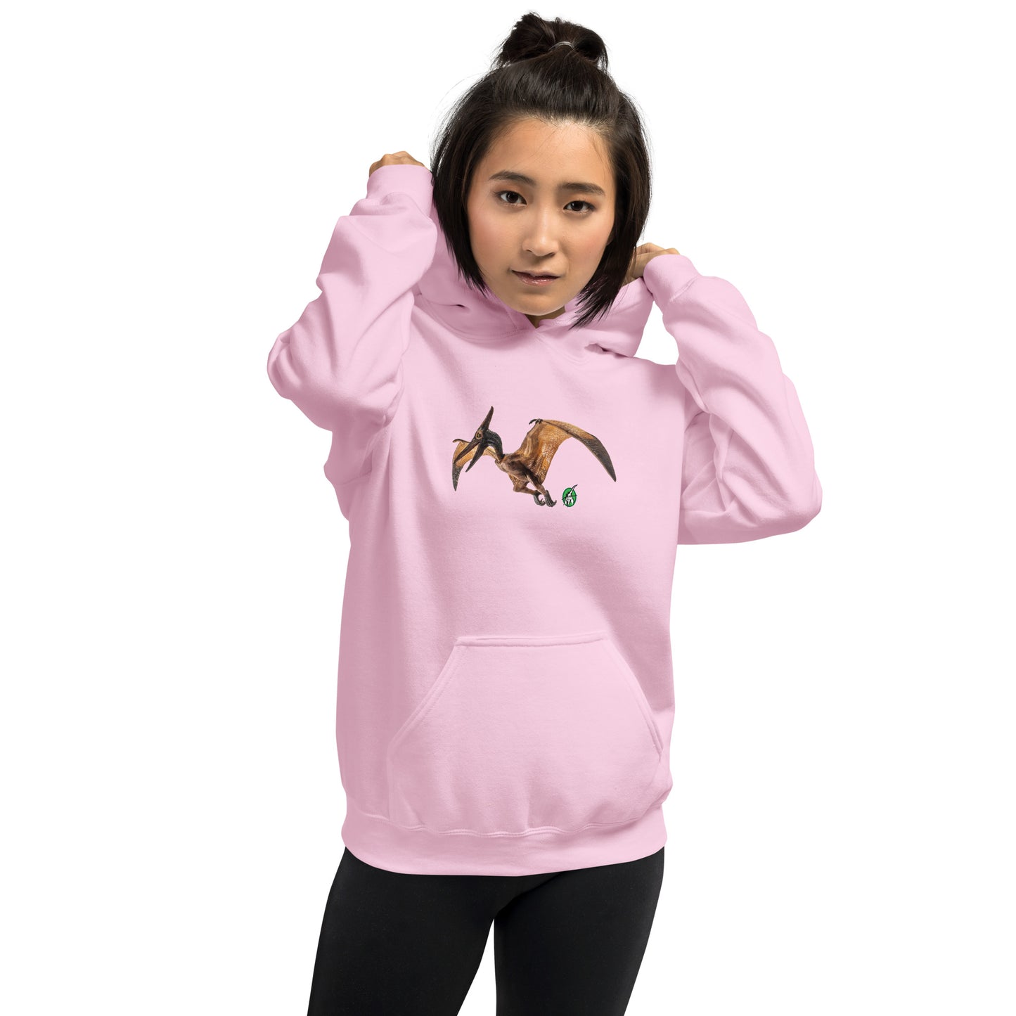 A woman standing wearing a light pink hoodie with a printed graphic of a life like pterodactyl dinosaur. Designed by Wizard Prints.
