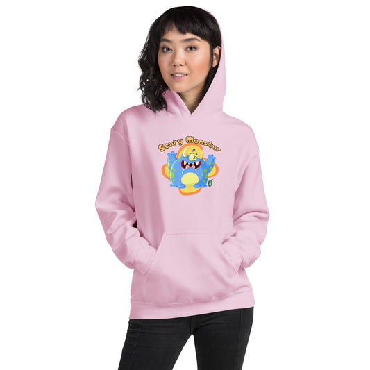 A woman standing wearing a light pink hoodie with a printed graphic of a cartoon monster and the words, Scary Monster. Designed by Wizard Prints.