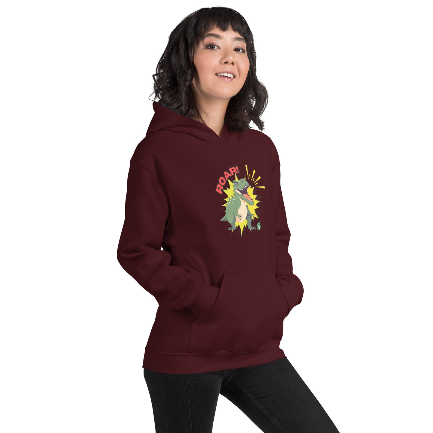 A woman standing wearing a maroon hoodie with a printed graphic of a green roaring cartoon dinosaur and the word Roar! Designed by Wizard Prints
