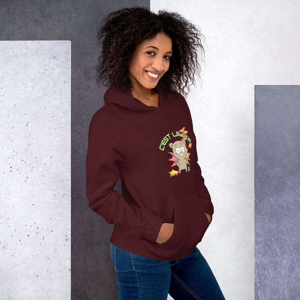 A woman standing wearing a maroon hoodie by Wizard Prints featuring a printed graphic of a shrugging cartoon bear and the words, C'est La Vie.