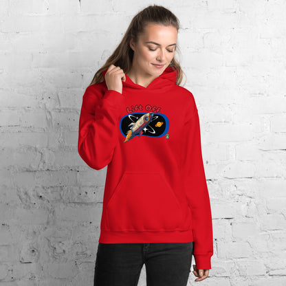 A woman standing wearing a red hoodie with a printed graphic of a rocket and the words, Lift Off. Designed by Wizard Prints.