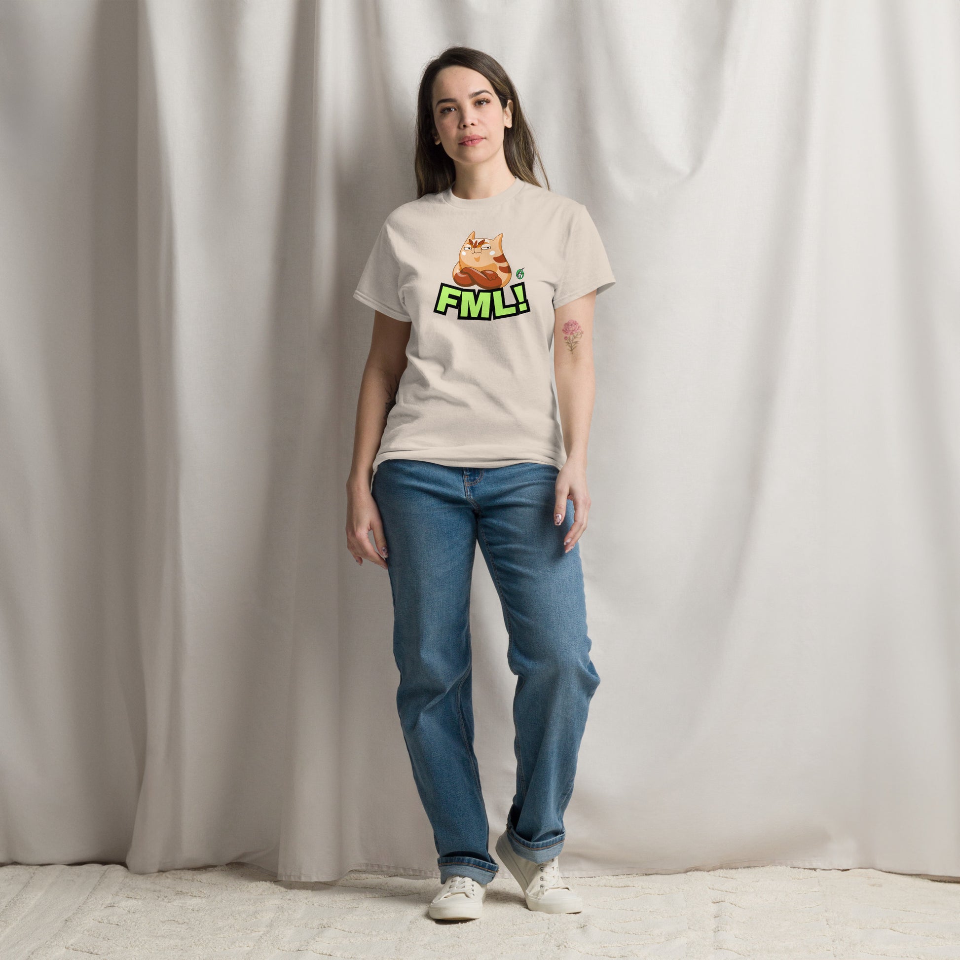 A woman standing and wearing a beige t-shirt with a printed graphic of a cat with the words, 'FML!'. Designed by Wizard Prints.