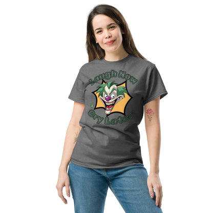 A woman standing wearing a dark grey t-shirt with a printed graphic of a clown with the words, 'Laugh Now, Cry Later'. Designed by Wizard Prints.