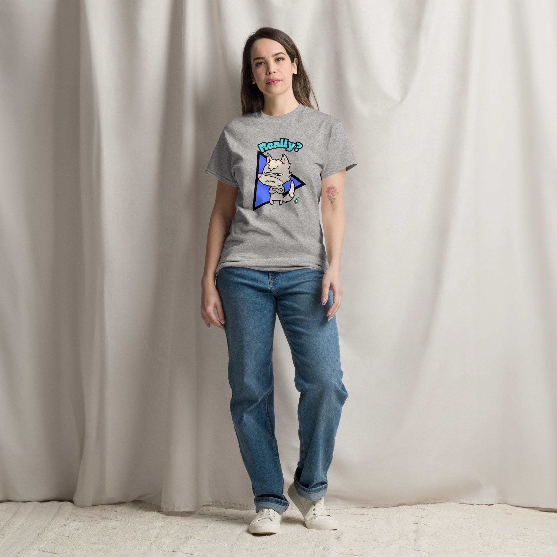 A woman standing wearing a grey t-shirt with a printed graphic of a grumpy fox with the word, 'Really?'. Designed by Wizard Prints.