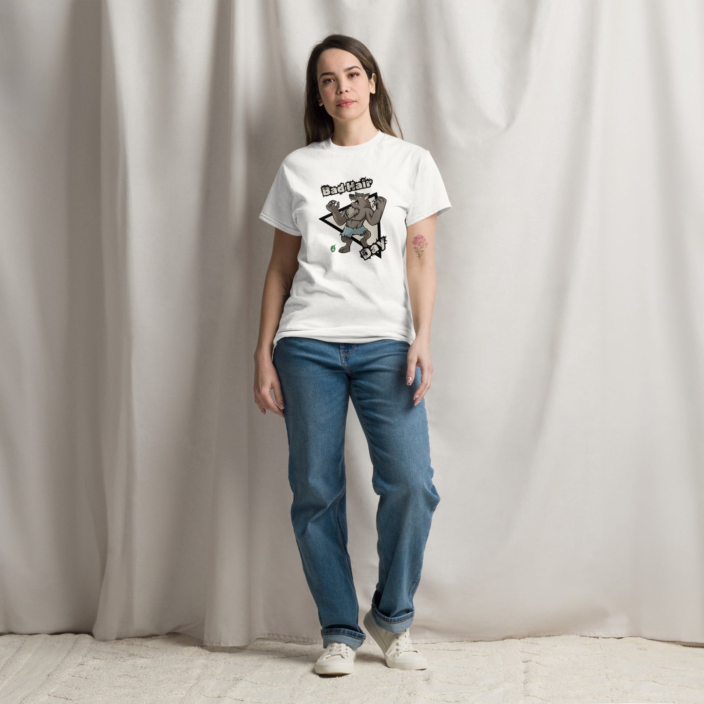 A woman standing and wearing a white t-shirt with a printed graphic of a werewolf with the words, Bad Hair Day. Designed by Wizard Prints.