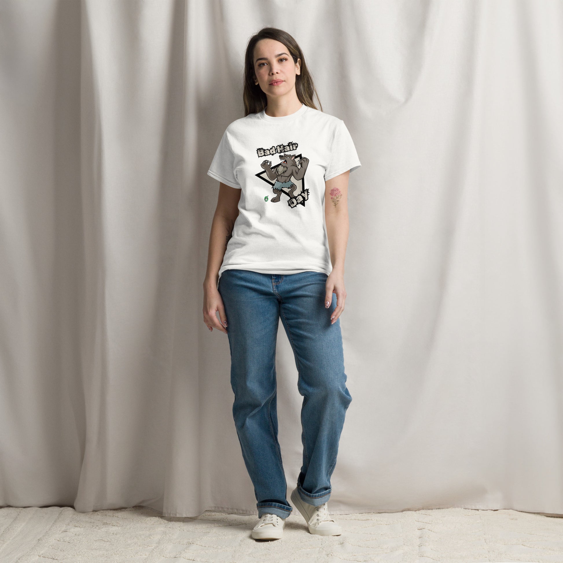 A woman standing and wearing a white t-shirt with a printed graphic of a werewolf with the words, Bad Hair Day. Designed by Wizard Prints.