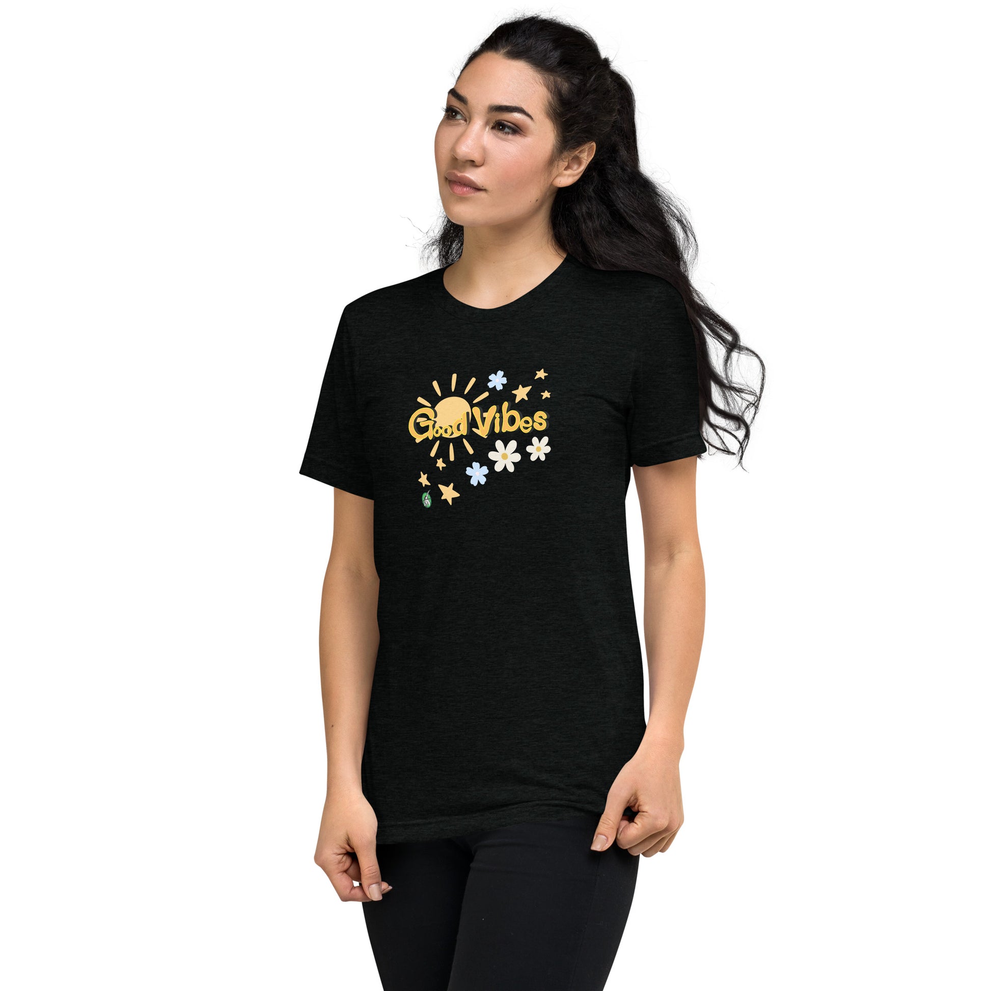 A woman standing wearing a black tee shirt with a printed graphic of the sun and the words, Good Vibes. Designed by Wizard Prints