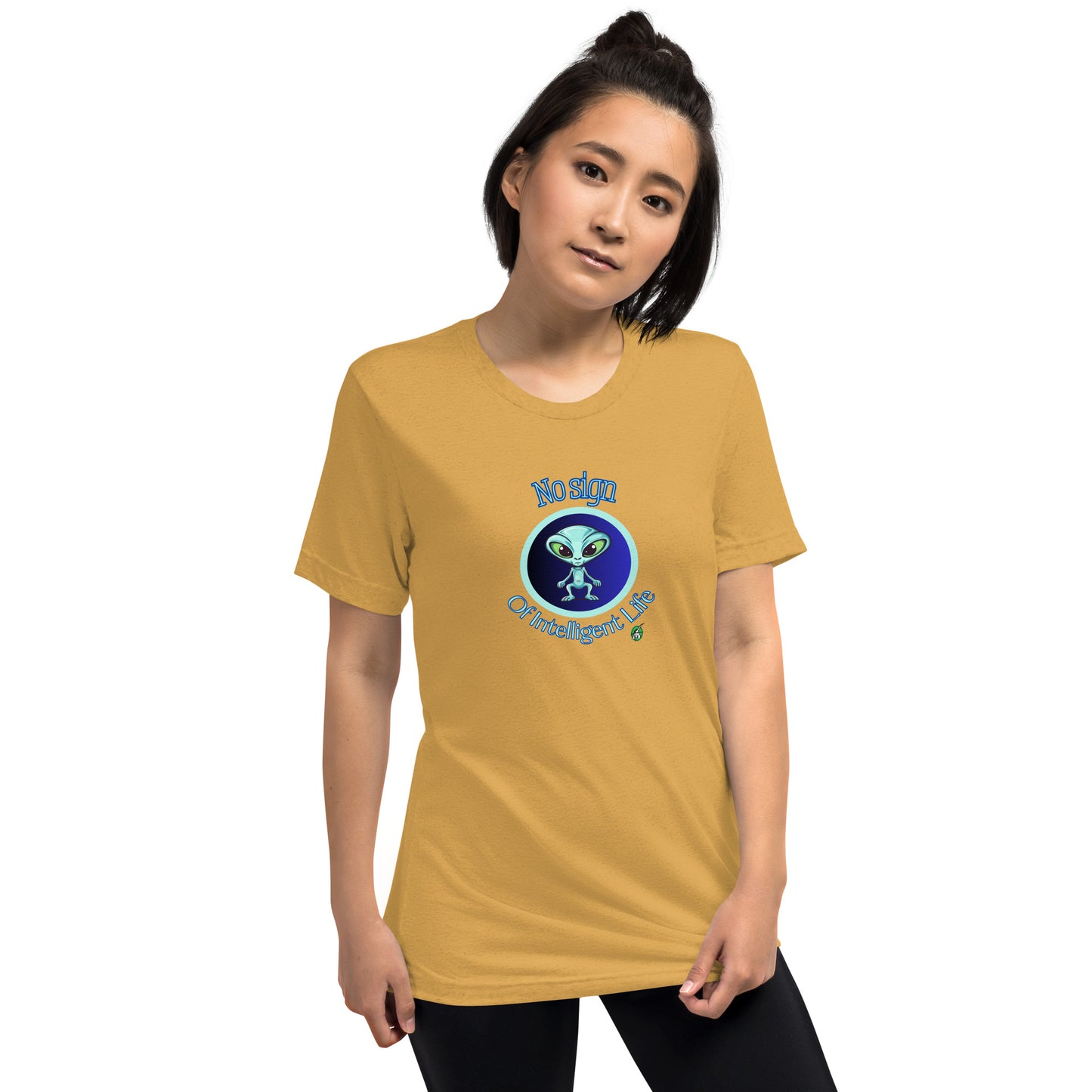 A woman standing wearing a mustard tee shirt with a printed graphic of a blue alien and the words No Sign of Intelligent Life. Designed by Wizard Prints