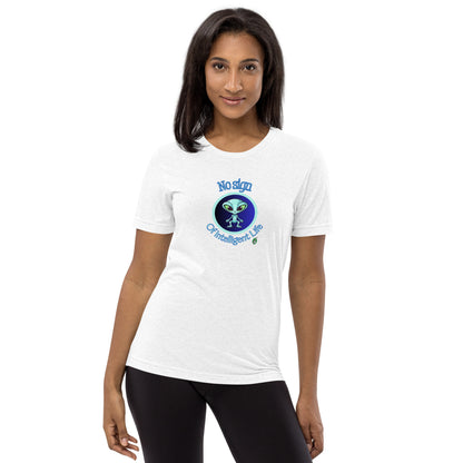 A woman standing wearing a white tee shirt with a printed graphic of a blue alien and the words No Sign of Intelligent Life. Designed by Wizard Prints