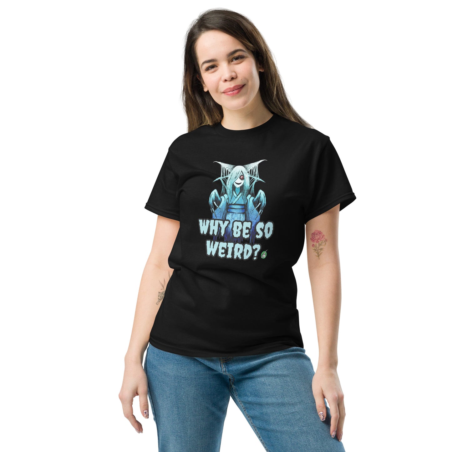 A woman standing and wearing a black t-shirt with a printed graphic of a blue ghost girl with the words, 'Why Be So Weird?'. Designed by Wizard Prints.