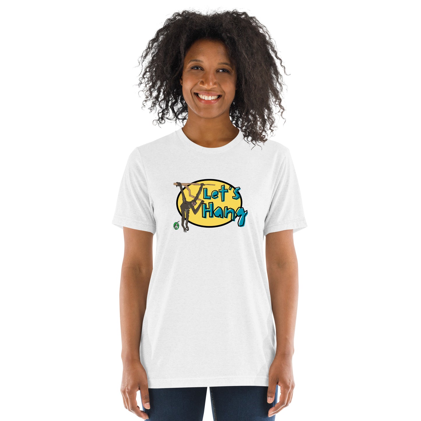 A woman standing wearing a white tee shirt with a printed graphic of a monkey hanging on a branch with the words, Let's Hang. Designed by Wizard Prints