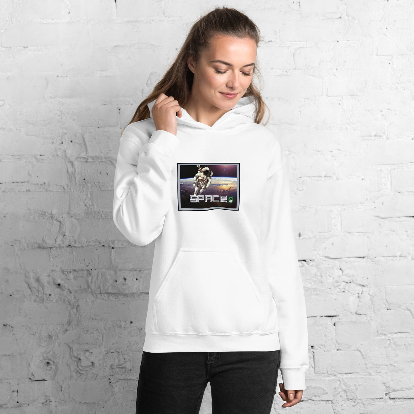 A woman standing wearing a white hoodie with the printed graphic of a real astronaut in space and the word, Space, by Wizard Prints.